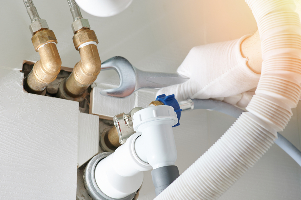 Professional plumber fixing pipework in a Sussex home