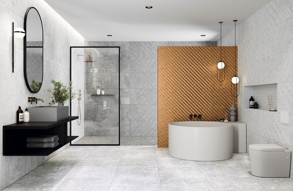 Modern bathroom featuring freestanding bath and walk-in shower with glass enclosure, grey tiles and gold accent wall.